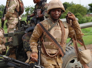 A soldier handling GPMG and its ammunition for the recapture of Damboa